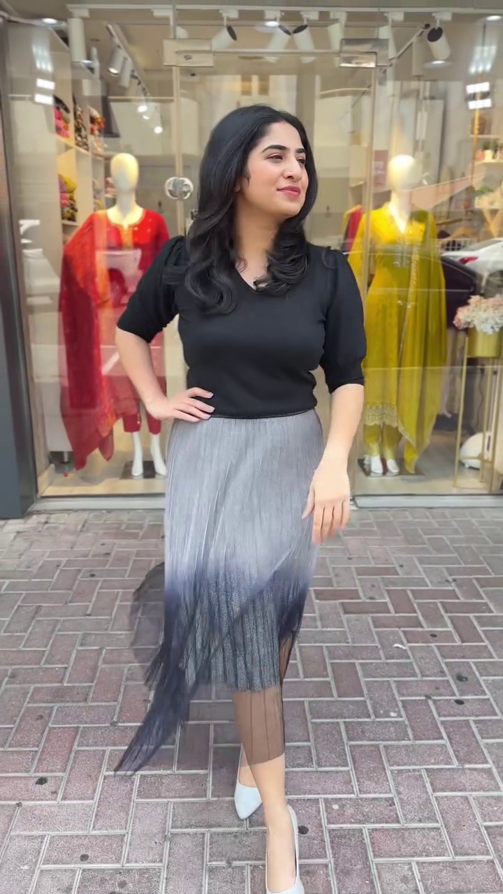 Chic black top paired with a pleated ombré skirt – A trendy and graceful look perfect for casual brunches or city strolls.