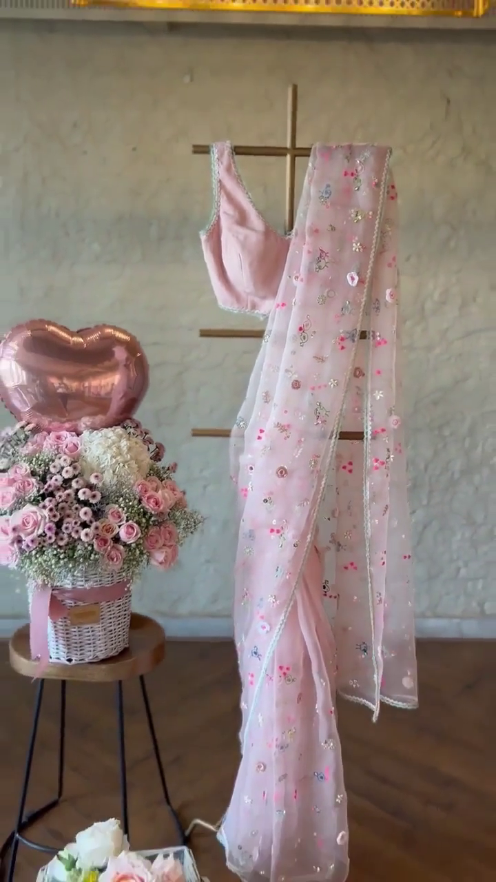 Soft Blush Pink Organza Saree and Sleeveless Blouse Set with Intricate Multicolor Floral Embroidery, Mirror Work, and Delicate Lace Trim for Elegant Festive or Ethnic Wear