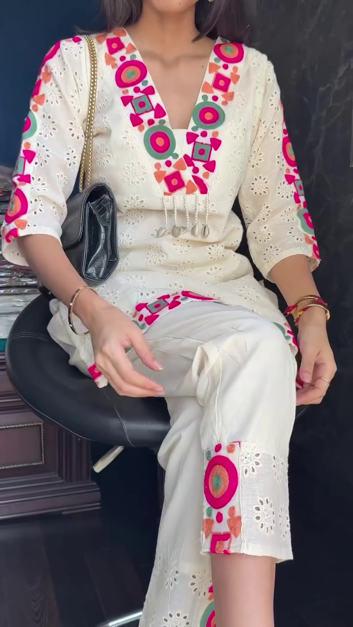 Off-White Cotton Kurti Set with Colorful Mirror-Inspired Thread Embroidery and Cutwork Detailing, Featuring V-Neckline Accents, Three-Quarter Sleeves, and Matching Pants with Coordinated Embellishments – Perfect for Casual and Festive Wear