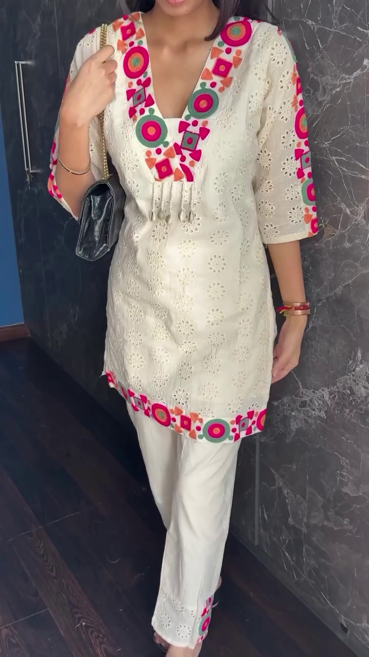Off-White Cotton Kurti Set with Colorful Mirror-Inspired Thread Embroidery and Cutwork Detailing, Featuring V-Neckline Accents, Three-Quarter Sleeves, and Matching Pants with Coordinated Embellishments – Perfect for Casual and Festive Wear