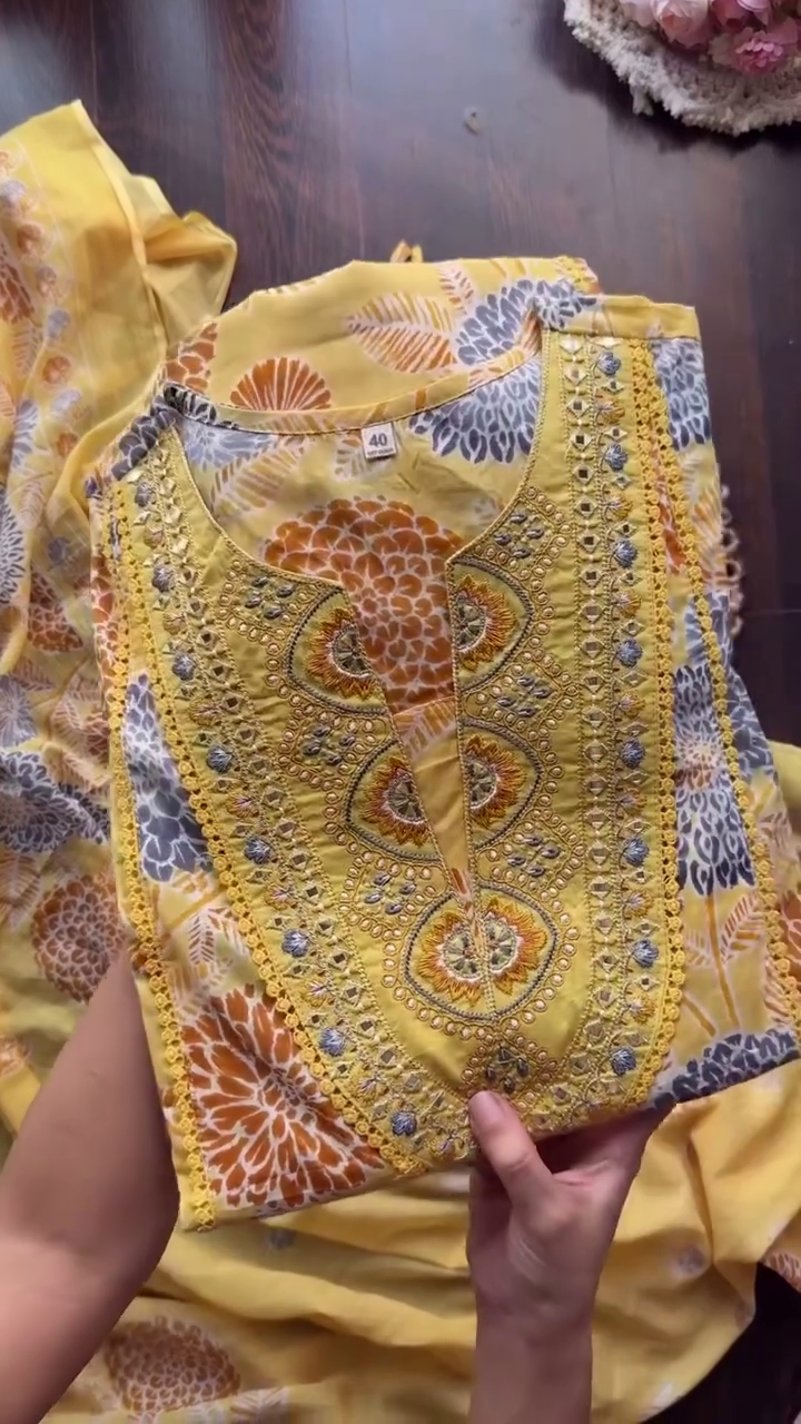 A cheerful yellow floral dress with intricate embroidery on the neckline, perfect for a sunny day outing or a casual gathering.     Ask ChatGPT