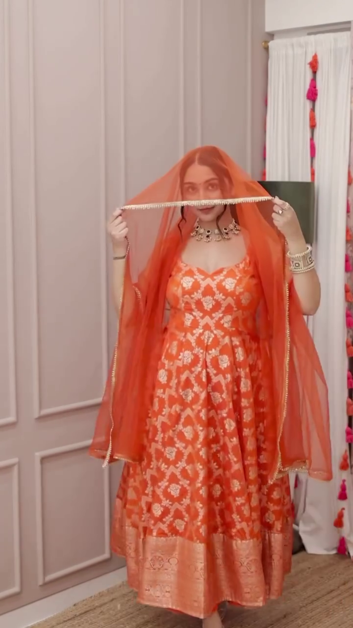 Radiant Orange Banarasi Silk Anarkali with Intricate Golden Zari Weaving and Matching Sheer Dupatta – Sleeveless Festive Ensemble Featuring Traditional Motifs and Rich Border Detailing, Perfect for Weddings, Navratri, and Grand Celebrations