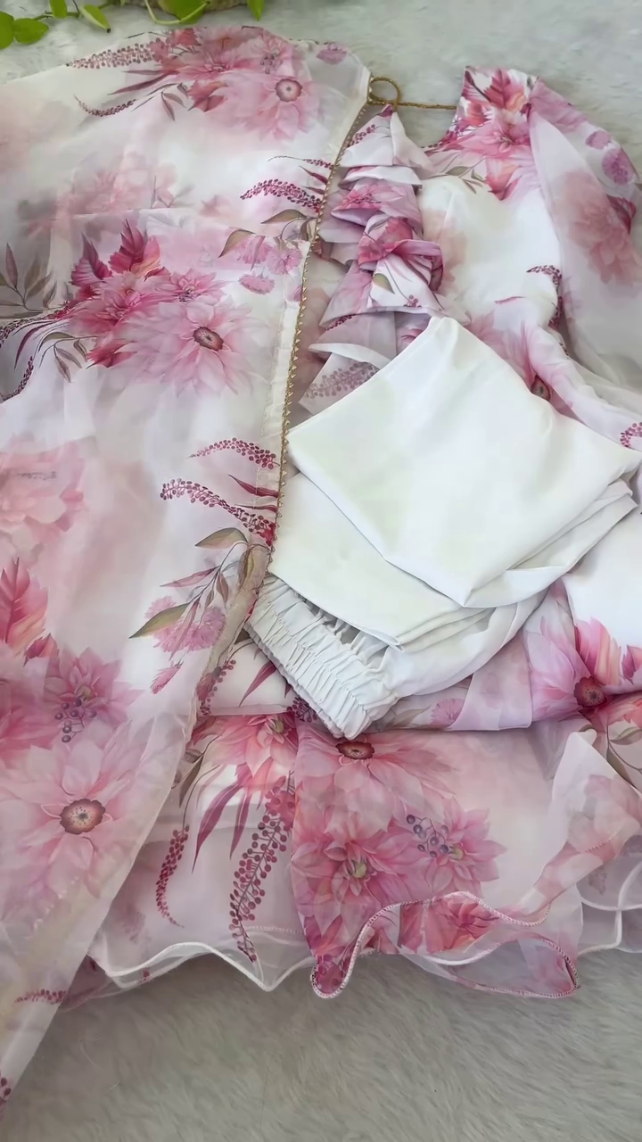 Charming Pink Floral Organza Partywear Set Featuring Ruffle Detailed Top with Sheer Layered Cape, Matching Printed Skirt with Net Underskirt for Added Flare, and Coordinated White Bottoms – A Perfect Blend of Elegance and Grace for Special Occasions