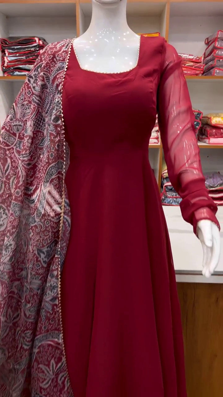 Graceful maroon Anarkali suit with a square neckline and sheer full sleeves. Paired with a printed chiffon dupatta featuring intricate traditional motifs.          Ask ChatGPT
